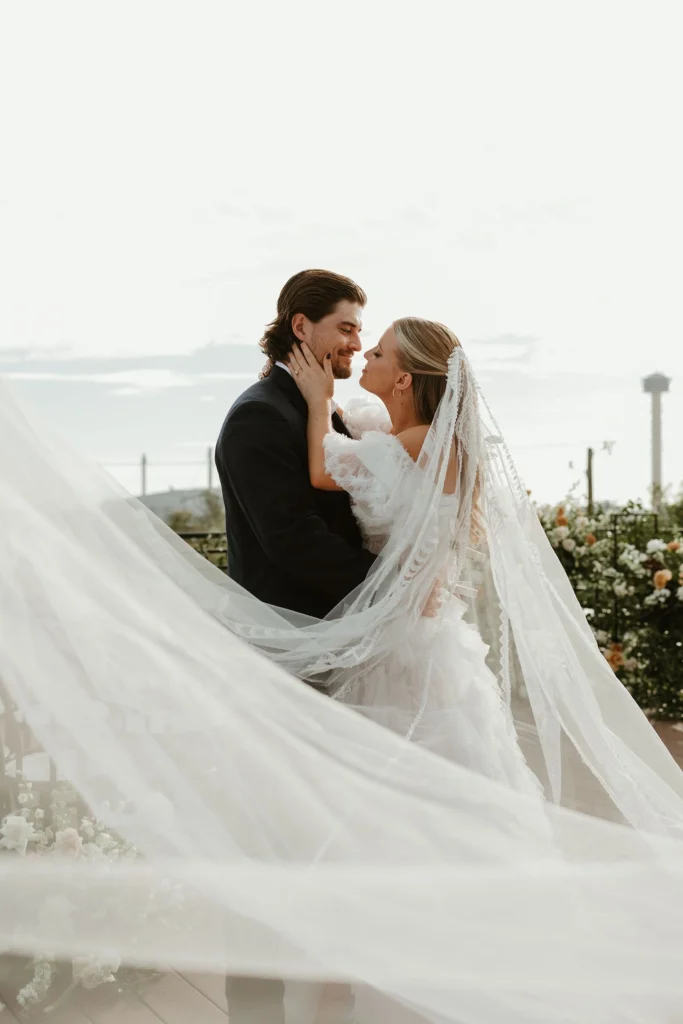 A bride and groom look into each other's eyes The San Antonio skyline is in the background