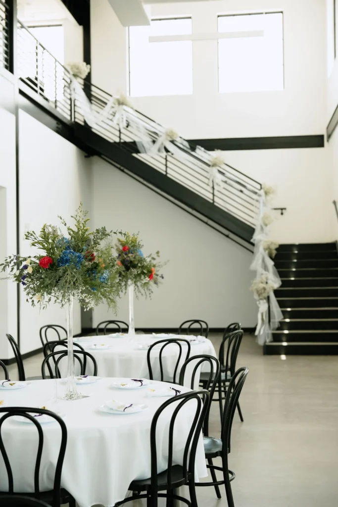 Tables in the foreground and a beautifully decorated staircase in the background.