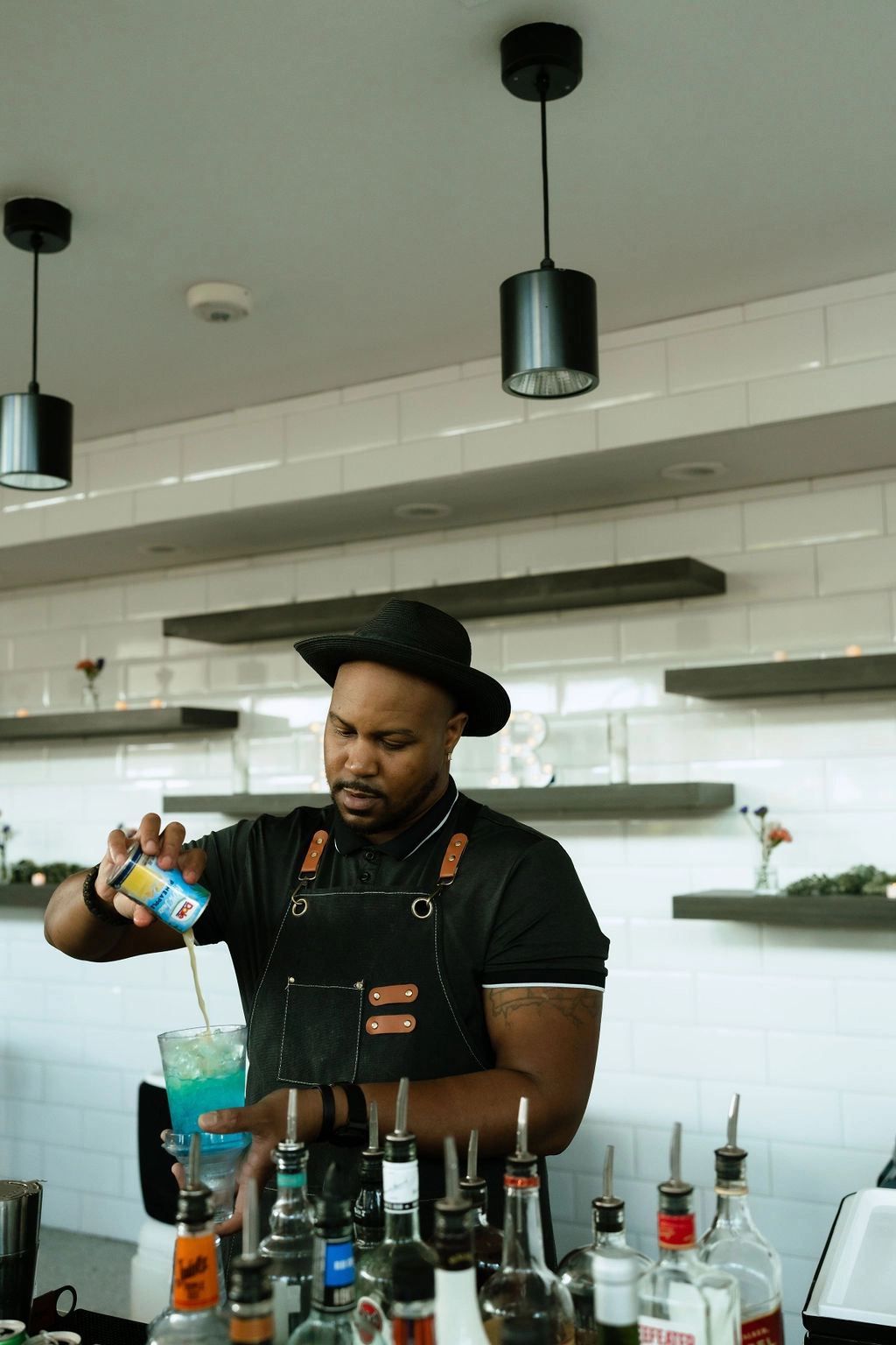 A mixologist pours a drink behind the bar