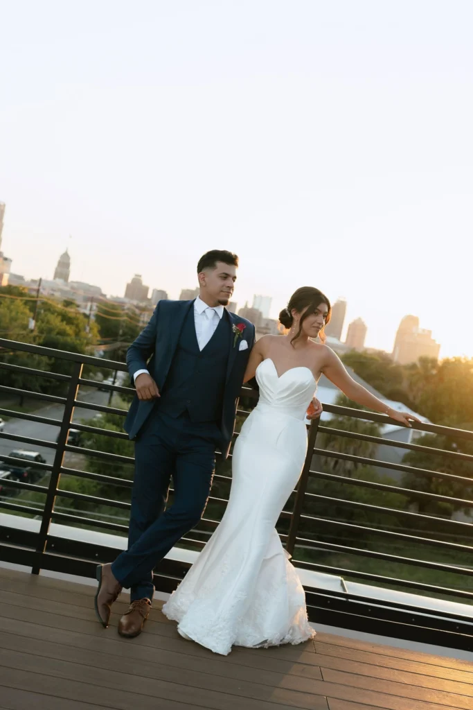 A bride and groom backlit by the son as they stand in front of the San Antonio Skyline