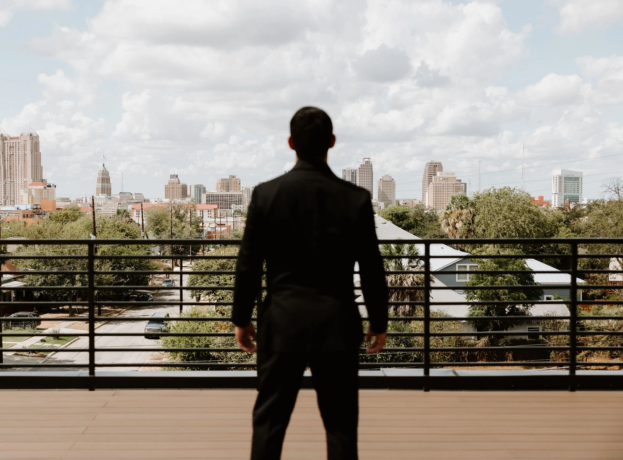 A groom stares off into the San Antonio skyline from our upper deck.