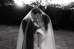 A bride and groom kiss underneath her veil