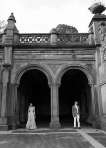 A bride and groom underneath arches