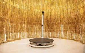 A 360 degree photo booth is set up with gold hanging all around.