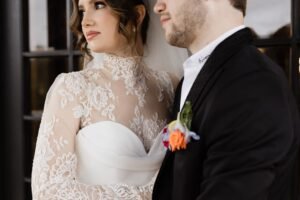 A bride and groom look pensively off into the distance